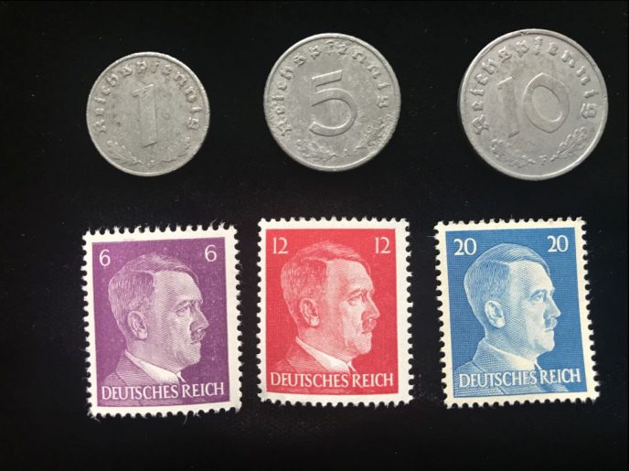 Close-up of WWII-era German Nazi coins and stamps in the 3-stamp and 3-coin set, certified by Gettysburg Museum of History