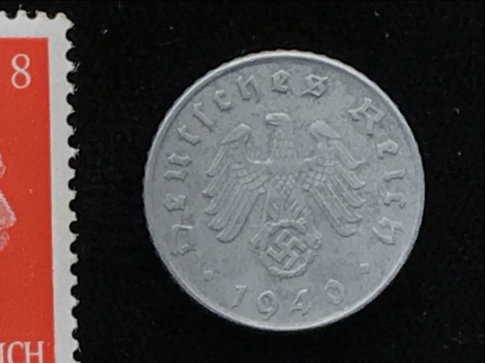 WWII-era German Nazi stamp and coin in a case, close-up of the certified set