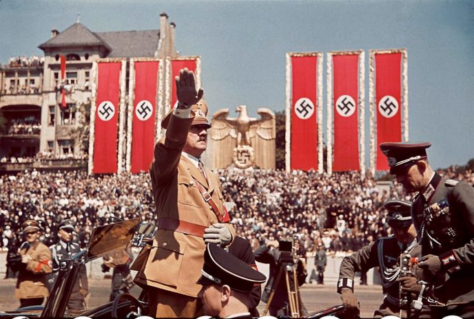 Color image of Adolf Hitler with a Nazi flag in the background during a speech