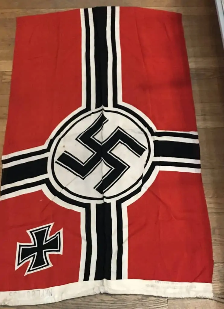 Close-up of the Nazi national war flag with clear maker's markings, part of a WWII exhibit