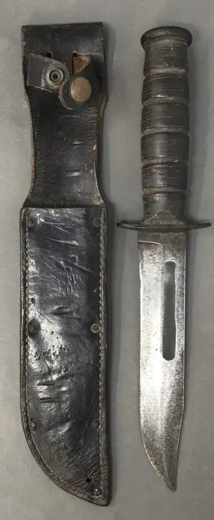 Close-up of WWII Navy Mark 2 Fighting Knife blade with leather sheath